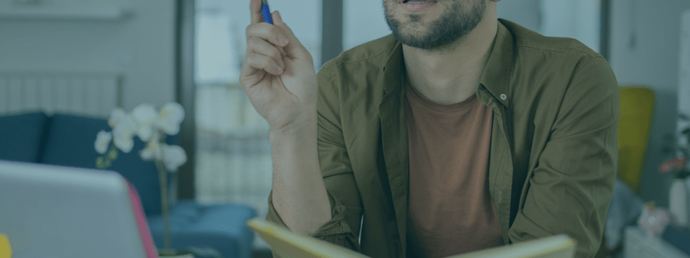 Learner studying remotely with a notepad and pen in hand